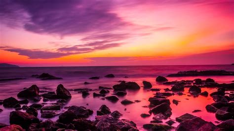 Download Pink Sunset On Rocky Beach Wallpaper