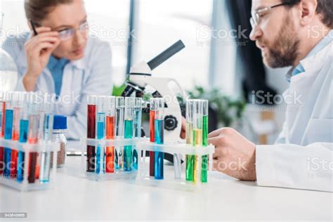 Selective Focus Of Scientists In Eyeglasses At Workplace With Flasks