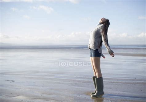 Young Woman Standing On Beach Looking Up Brean Sands Somerset