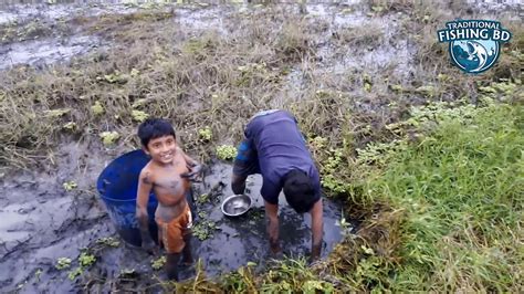 Traditional Village Fishing Boy Catching Fish From Mud Water In Dry