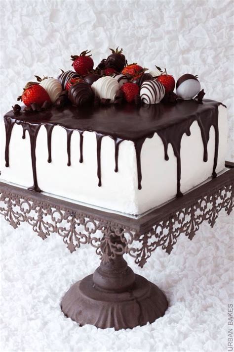 square chocolate drip cake with chocolate covered strawberries white chocolate frosting