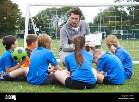 Coach Giving Team Talk To Elementary School Soccer Team Stock Photo Alamy