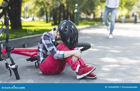 Crying Girl In Helmet Sitting On The Park Road Stock Image Image Of