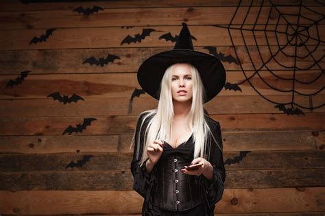 free photo halloween witch concept happy halloween sexy witch holding posing over old wooden