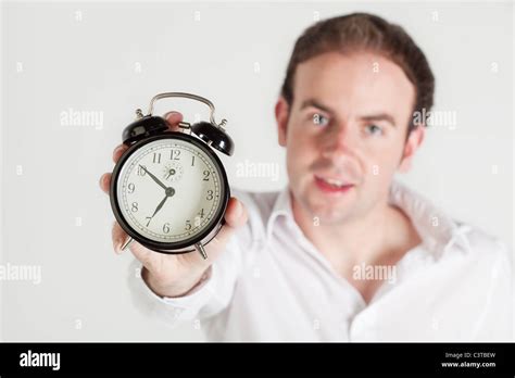 Man Holding Alarm Clock Towards The Camera Clock Dial In Focus Man