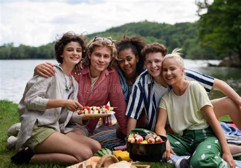 Group Of Multiracial Young Friends Camping Near Lake And And Having
