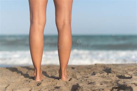 Female Barefoot Legs On Sandy Beach Near Waving Sea Stock Photo Image