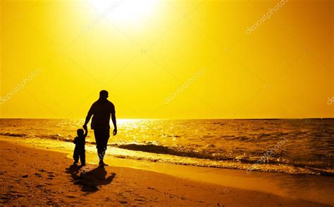 Siluetas De Padre E Hijos En La Playa Al Atardecer Fotografía De Stock