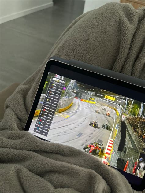 A Person Is Holding A Tablet With A Video Game On The Screen In Their Lap