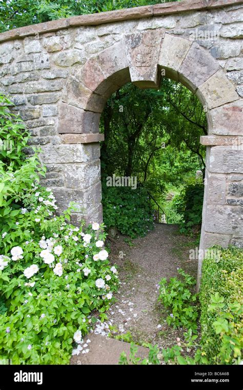 Stone Archway In Old Garden Wall With Prominant Keystone Leading Down