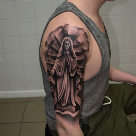 Black And Grey Virgin Mary Tattoo On The Upper Arm
