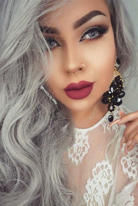 sexy caucasian brunette woman with a septum piercing wearing a grey dress and silver jewelry
