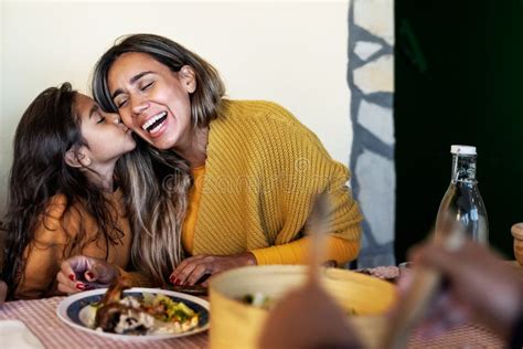 Feliz Madre Hispana Teniendo Un Momento Tierno Con Su Hija Mientras Cenan Junto A Su Familia