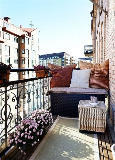 An Apartment Balcony With Lots Of Furniture And Pillows On The Top