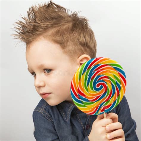 A Boy In A Denim Shirt Eating Lollipop Stock Image Image Of Happy