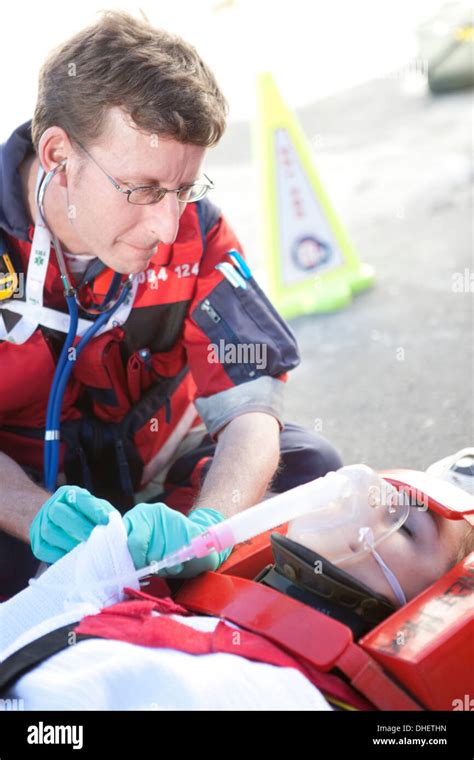 Paramedic Using Stethoscope Patient On Stretcher Wearing Oxygen Mask