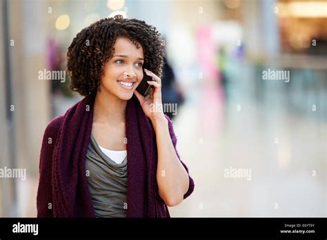 Woman In Shopping Mall Using Mobile Phone Stock Photo Alamy