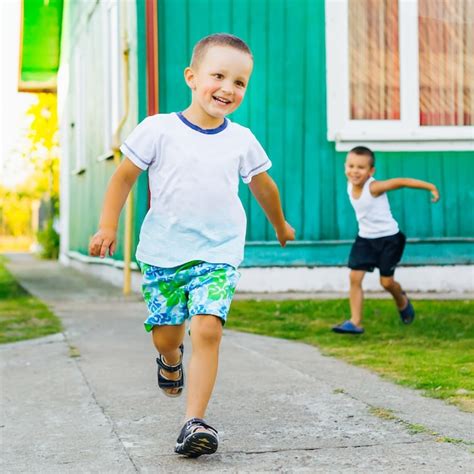 Dos Niños Pequeños Corren Y Juegan En El Patio Cerca De La Casa En Un