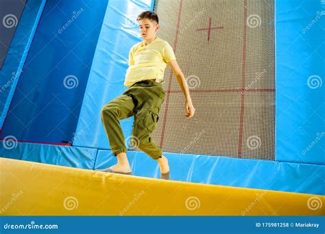 Teenage Boy Jumping On Trampoline Park In Sport Center Stock Photo