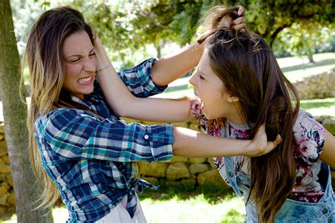 Two Teenager Friends Fighting In Park Angry Pulling Long Hair Stock
