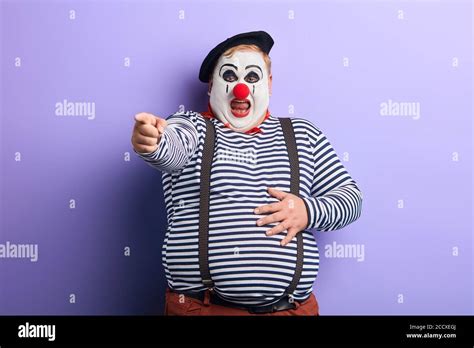 Fat Clown Showing Direction With Index Finger Isolated Blue Background