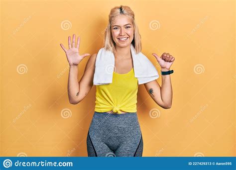 beautiful blonde sports woman wearing workout outfit showing and pointing up with fingers number