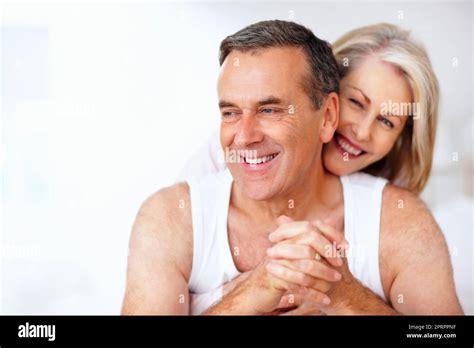 Cheerful Mature Woman Embracing Husband From Back Against White