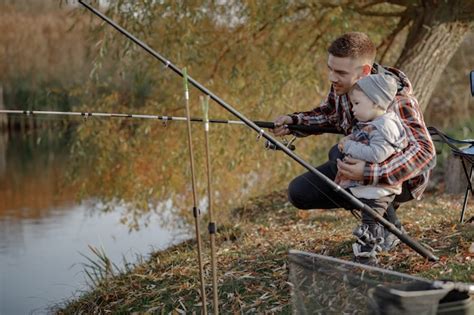 Padre Con Hijo Pequeño Cerca Del Río En Una Mañana De Pesca Foto Gratis