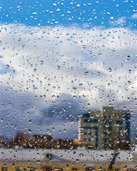 Rain Drops On Window Glasses Surface With Blue Sky Buildings And