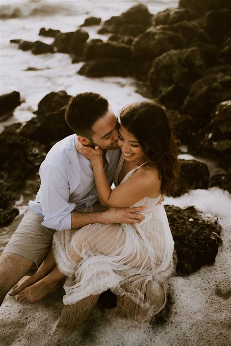 Beach Engagement Shoot In The Water By Rocks Beach Engagement Photos Romantic Engagement