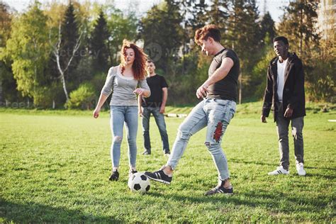 A Group Of Friends In Casual Outfit Play Soccer In The Open Air People