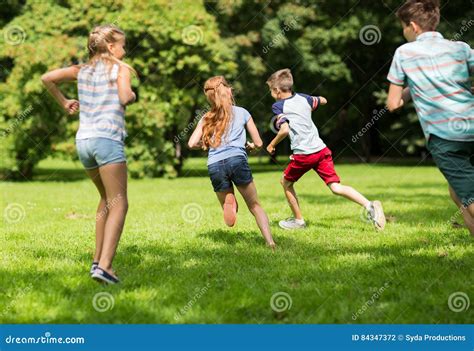 Group Of Happy Kids Or Friends Playing Outdoors Stock Photo Image Of