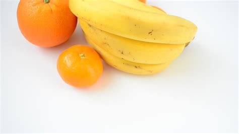 Bananas And Oranges On White Surface Free Stock Video Mixkit