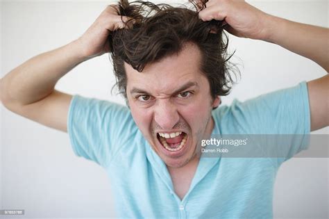 Young Man Pulling His Hair Looking Stressed High Res Stock Photo