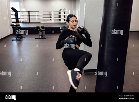 Strong Latin Boxing Woman Jump Kick To Huge Punching Bag At Fitness Gym