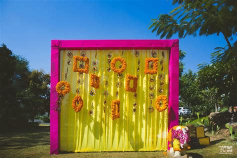 Photo Of Mehendi Photo Booth Idea With Yellow Backdrop And Genda Pool