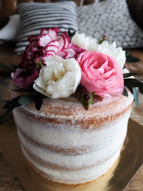A Close Up Of A Cake On A Plate With Pink And White Flowers In It
