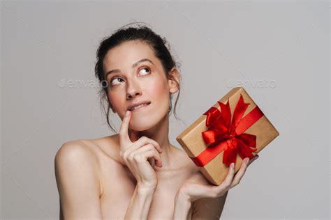 Pleased Half Naked Woman Thinking While Showing Gift Box Stock Photo By