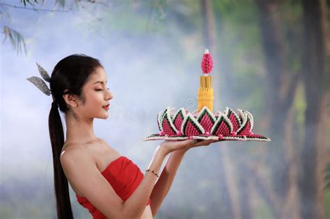 Beautiful Woman In Traditional Thai Red Dress Holding Krathong Flower In Her Hands In Loy