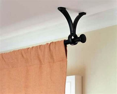 Attach the curtains to the track curtain clips. Hang a curtain rod from the ceiling instead of the wall ...