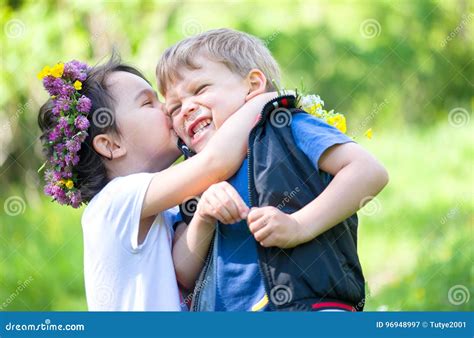 Kleines Mädchen Das Einen Kleinen Jungen In Der Sommerzeit Küsst Stockbild Bild Von Liebe