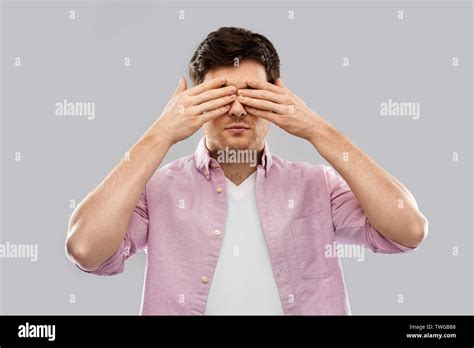 Man Closing His Eyes By Hands Over Grey Background Stock Photo Alamy
