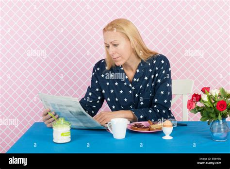 Mature Woman Reading Newspapers In The Morning While Having Breakfast Stock Photo Alamy