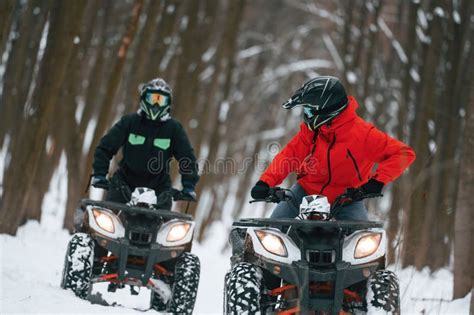 Front View Two People Are Riding Atv In The Winter Forest Stock Image