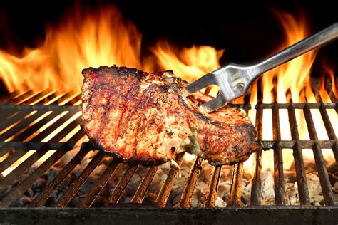 Meat Chop Cooked On The Barbecue Grill Flame Of Fire In The Background