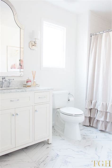 A White Bathroom With Marble Flooring And Vanity Shower Curtain