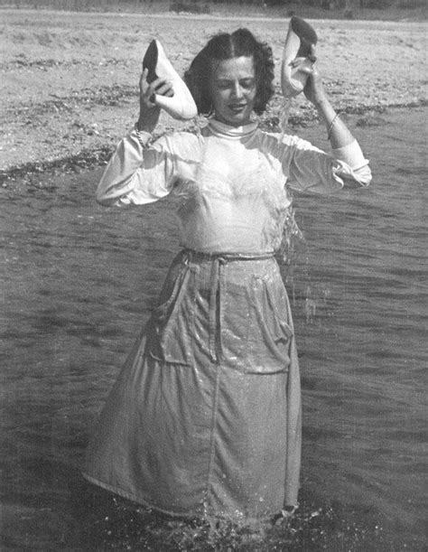 An Old Photo Of A Woman Standing In The Water