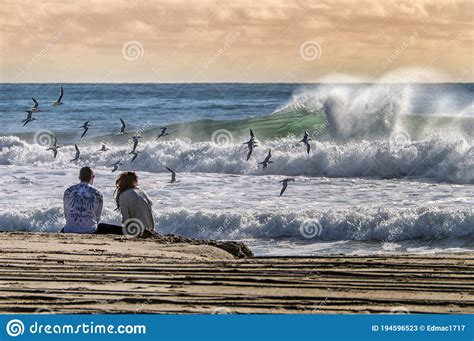 Romantic Scene With Couple Watching The Waves At Malibu Beach At Sunset