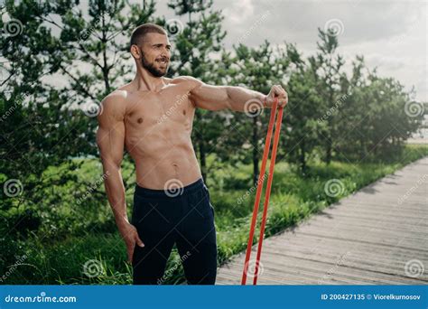 Strength And Motivation Concept Muscular Man With Naked Torso Has Exercises With Resistance