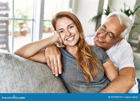 Middle Age Hispanic Couple Smiling Happy And Hugging Sitting On The